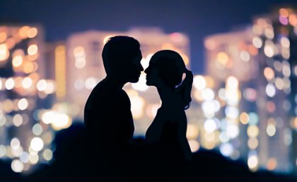 Adobe Stock A man and woman in silhoette facing each other with coloured lights behind